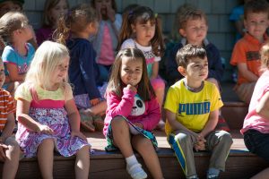 young kids sitting on steps outside of school