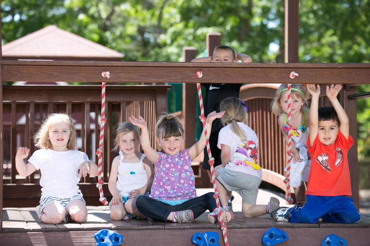 young school kids playing on jungle gym