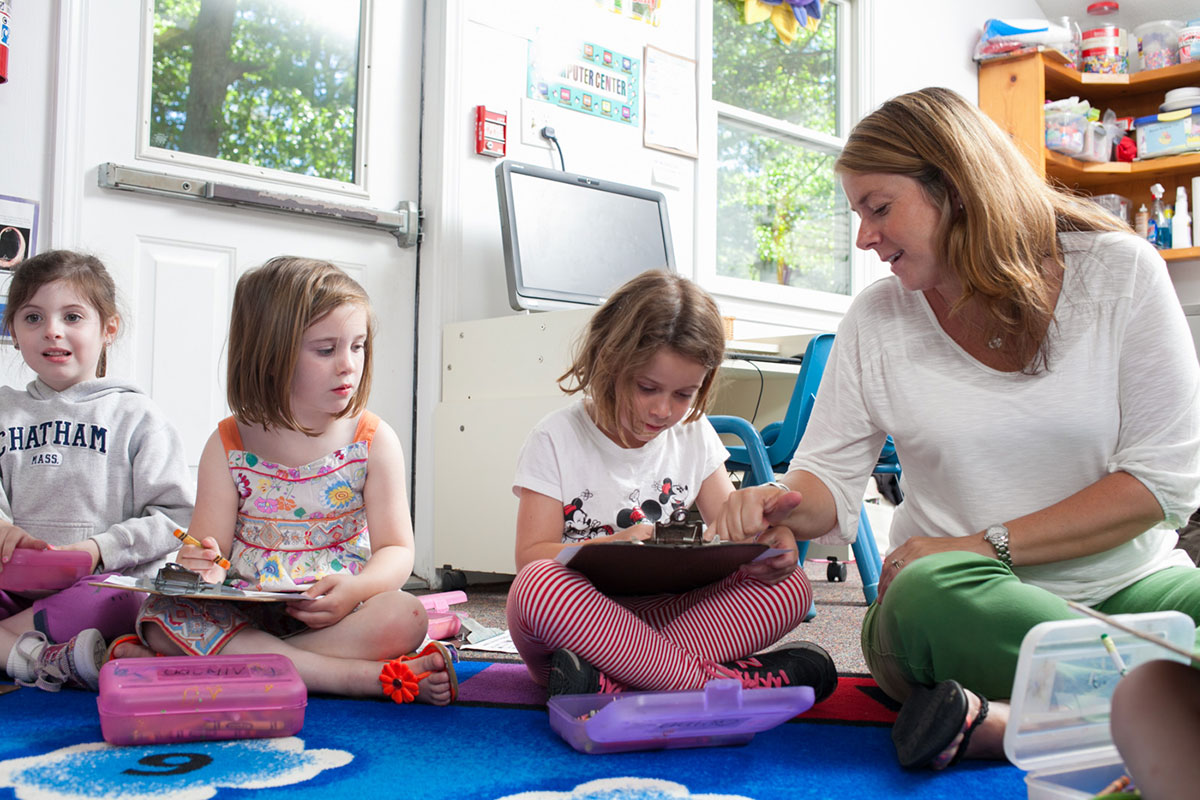 teacher helping young girl with school work