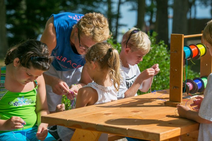 camp staff member doing arts & crafts with kids