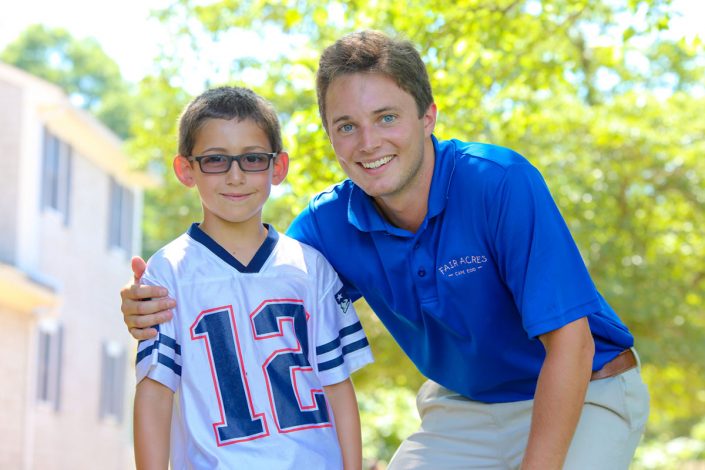 male camp staff member with young boy posing for the camera